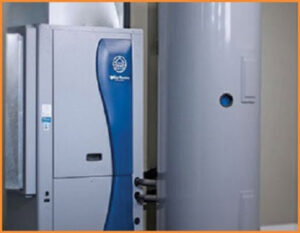 An HVAC technician consulting with customers next to an outdoor unit, representing Stevens Refrigeration & Heating in Enid, OK