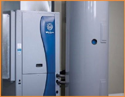 An HVAC technician consulting with customers next to an outdoor unit, representing Stevens Refrigeration & Heating in Enid, OK