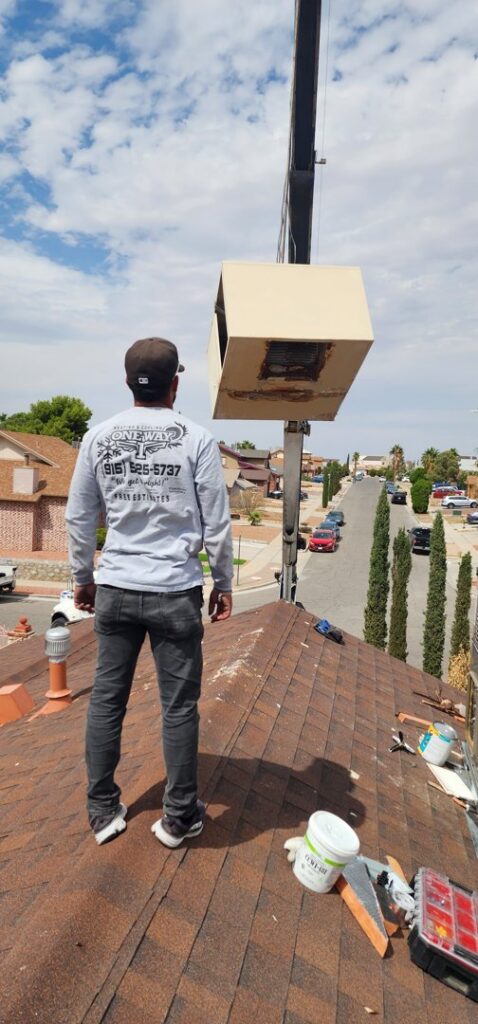 An HVAC technician overseeing a unit being lifted by a crane for One Way Heating And Cooling, LLC in Horizon City, TX.
