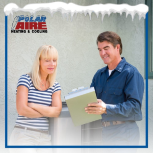 An HVAC technician from Polar Aire Heating & Cooling discussing service with a customer next to an outdoor AC unit in Olathe, KS
