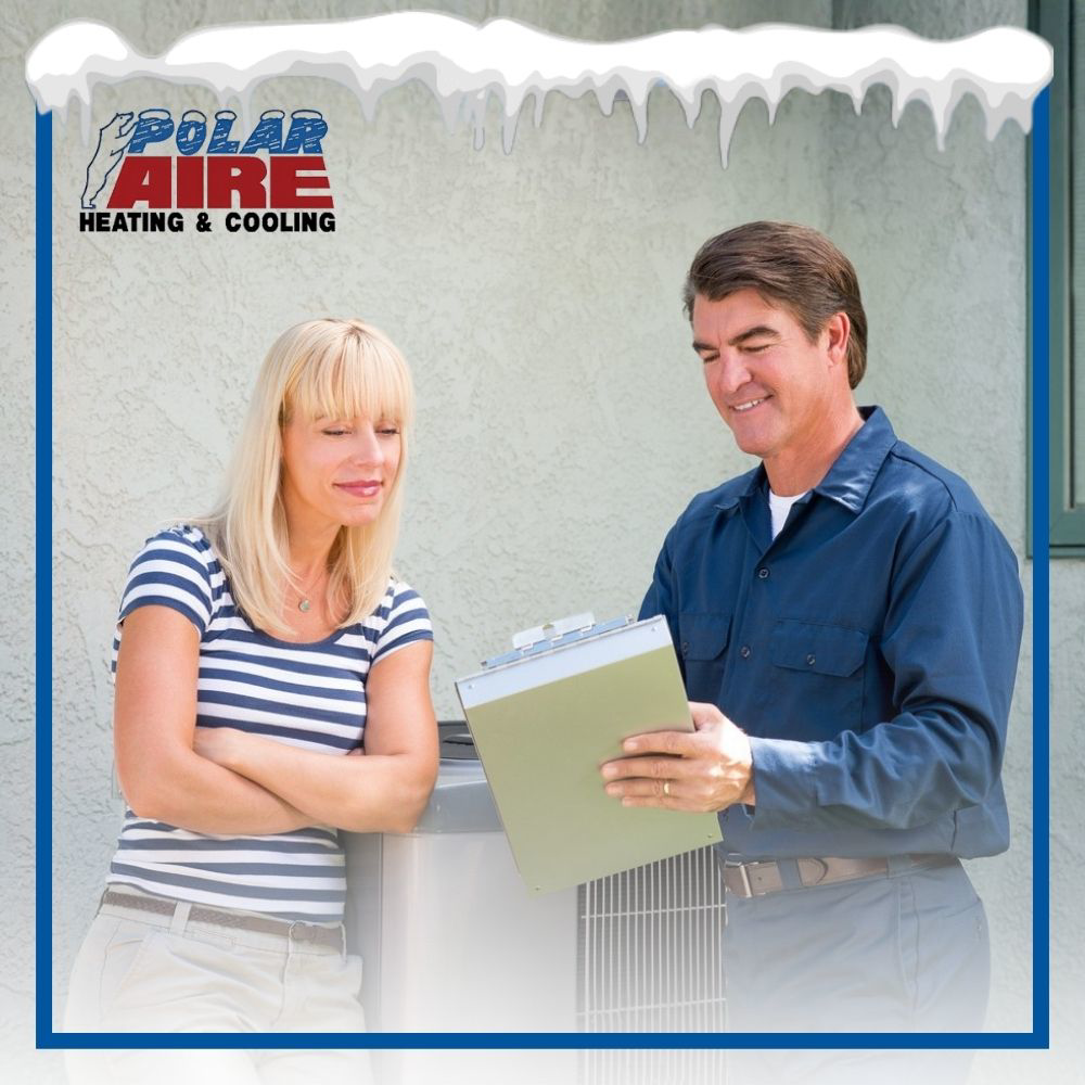 An HVAC technician from Polar Aire Heating & Cooling discussing service with a customer next to an outdoor AC unit in Olathe, KS