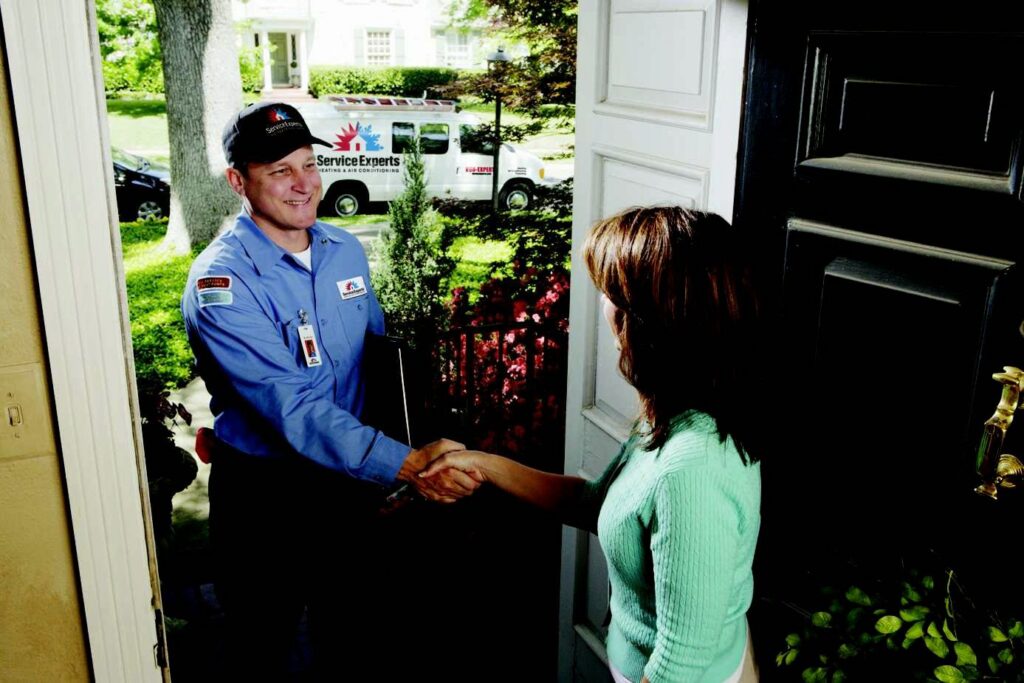 An HVAC technician from McElroy Service Experts greeting a customer at their home in Grand Island, NE.