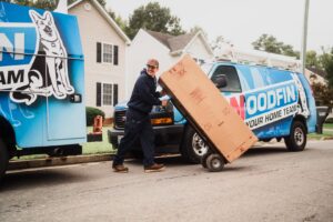An HVAC technician from Woodfin-Your Home Team delivering a new unit on a dolly in Richmond, VA.
