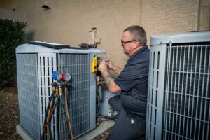 An HVAC technician diagnosing an outdoor AC unit with a multimeter for AVI Heating & Cooling in Surprise, AZ