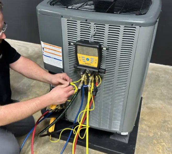 An HVAC technician connecting diagnostic gauges to an outdoor air conditioning unit, performing service for Prime Home HVAC in York, PA.