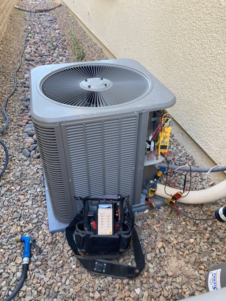 An HVAC technician diagnosing an outdoor air conditioning unit with professional tools for Sahara Air Conditioning & Heating in Las Vegas, NV