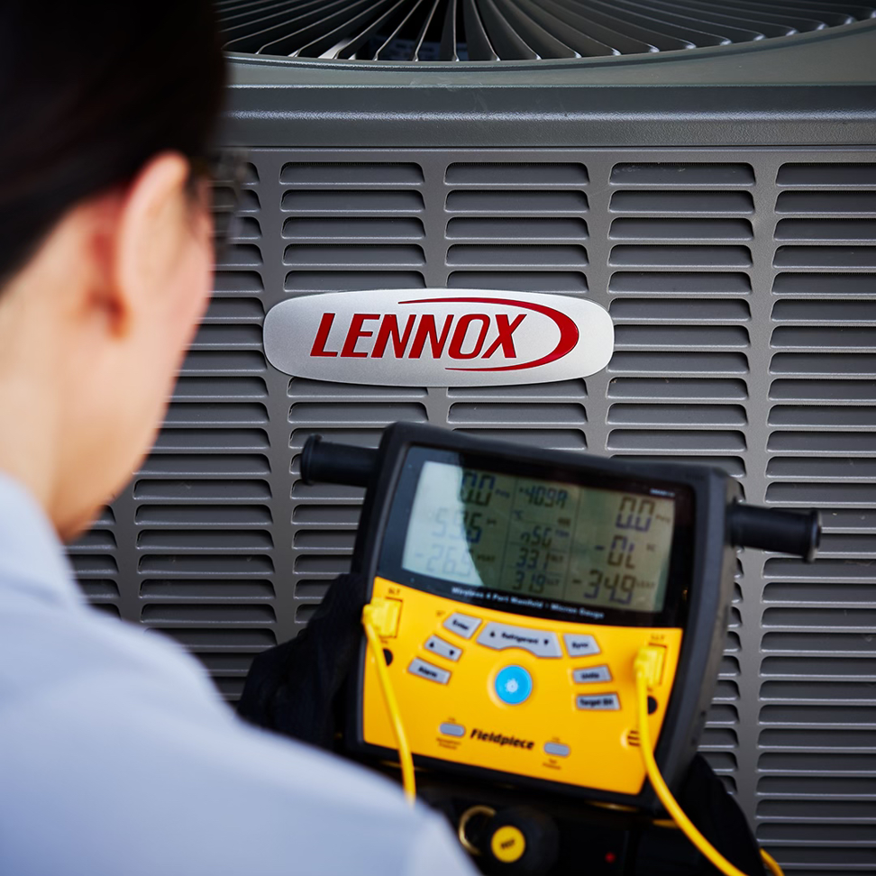 An HVAC technician diagnosing an outdoor AC unit with a digital manifold at Unified Home Solutions in Stamford, CT.