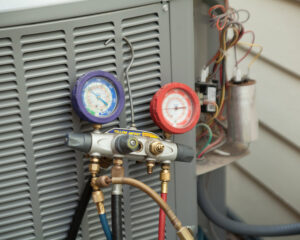 Close-up of an HVAC technician using gauges to diagnose an air conditioning unit for Any Climate Mechanical HVAC in Sandy, UT.