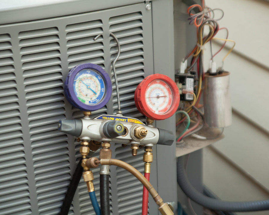Close-up of an HVAC technician using gauges to diagnose an air conditioning unit for Any Climate Mechanical HVAC in Sandy, UT.