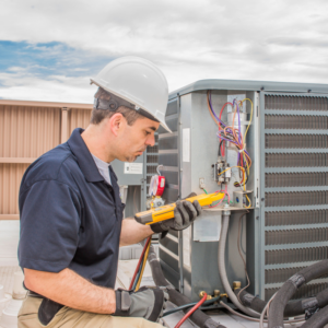 An HVAC technician from Polar Aire Heating & Cooling diagnosing a commercial rooftop unit in Olathe, KS
