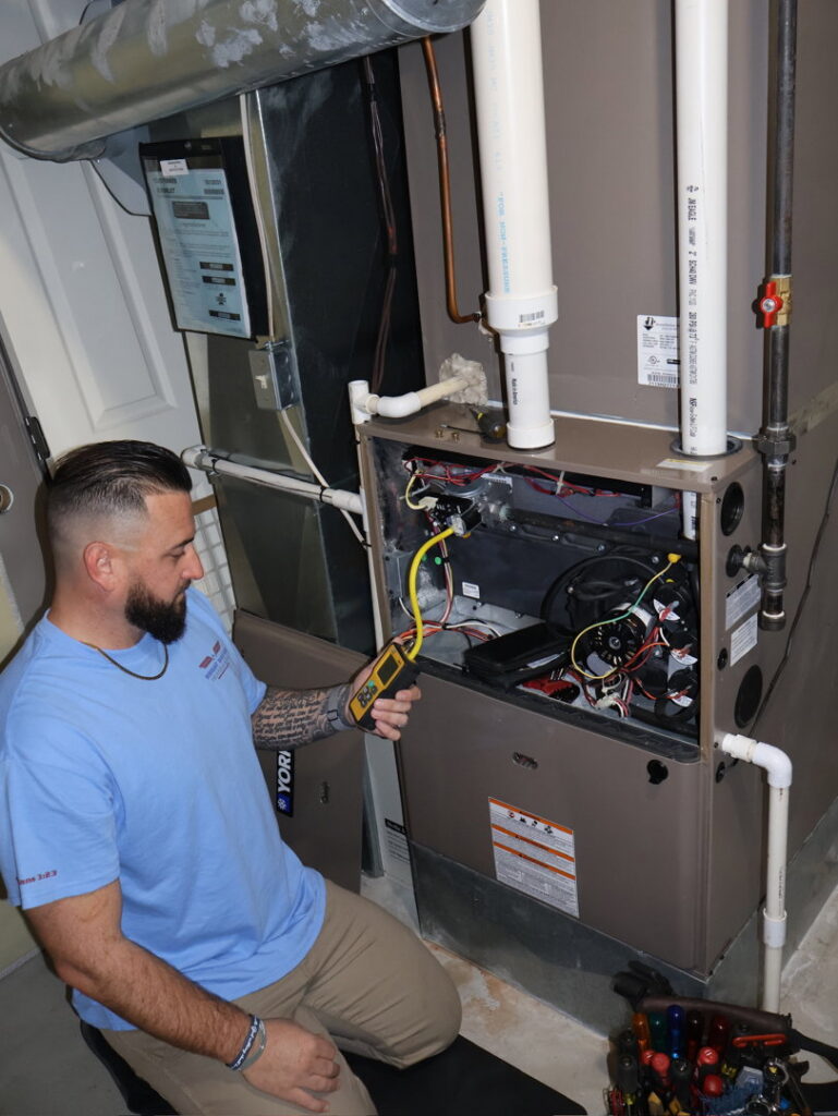 An HVAC technician diagnosing an issue with an open furnace using a meter for Wright Way Air in Streamwood, IL