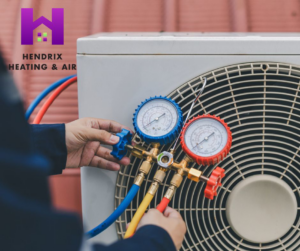 An HVAC technician diagnosing an outdoor air conditioning unit with gauges for Hendrix Heating & Air in Newport News, VA.