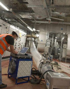 An HVAC technician performing duct testing in a commercial or industrial setting for Aspen Air Duct Cleaning in Methuen, MA.