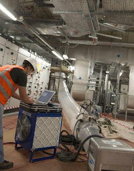 An HVAC technician performing duct testing in a commercial or industrial setting for Aspen Air Duct Cleaning in Methuen, MA.