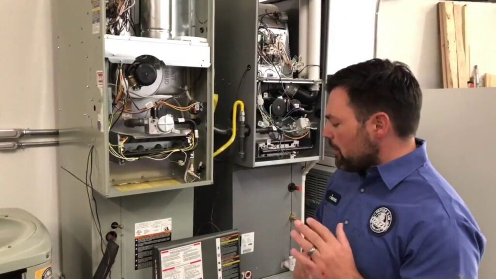 An HVAC technician explaining furnace components to a client at Access Heating & Air Conditioning in Fredericksburg, VA