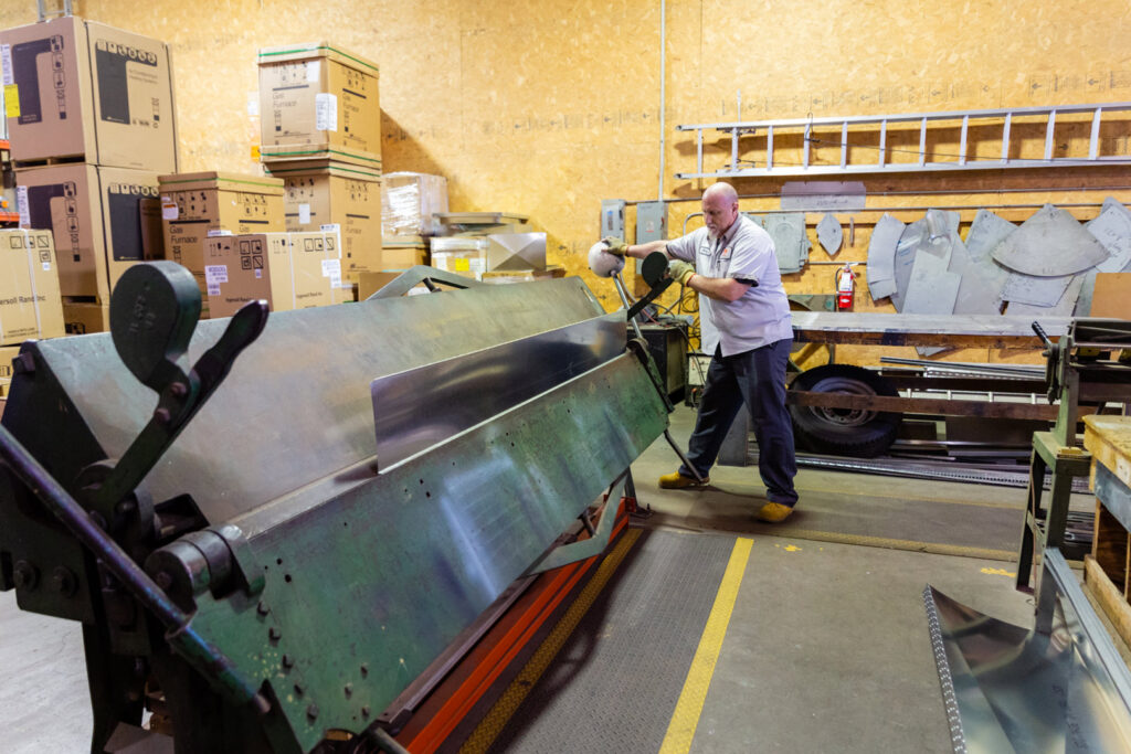 An HVAC technician from DFH Company Heating and Air Conditioning fabricating sheet metal ductwork in their Louisville, KY workshop