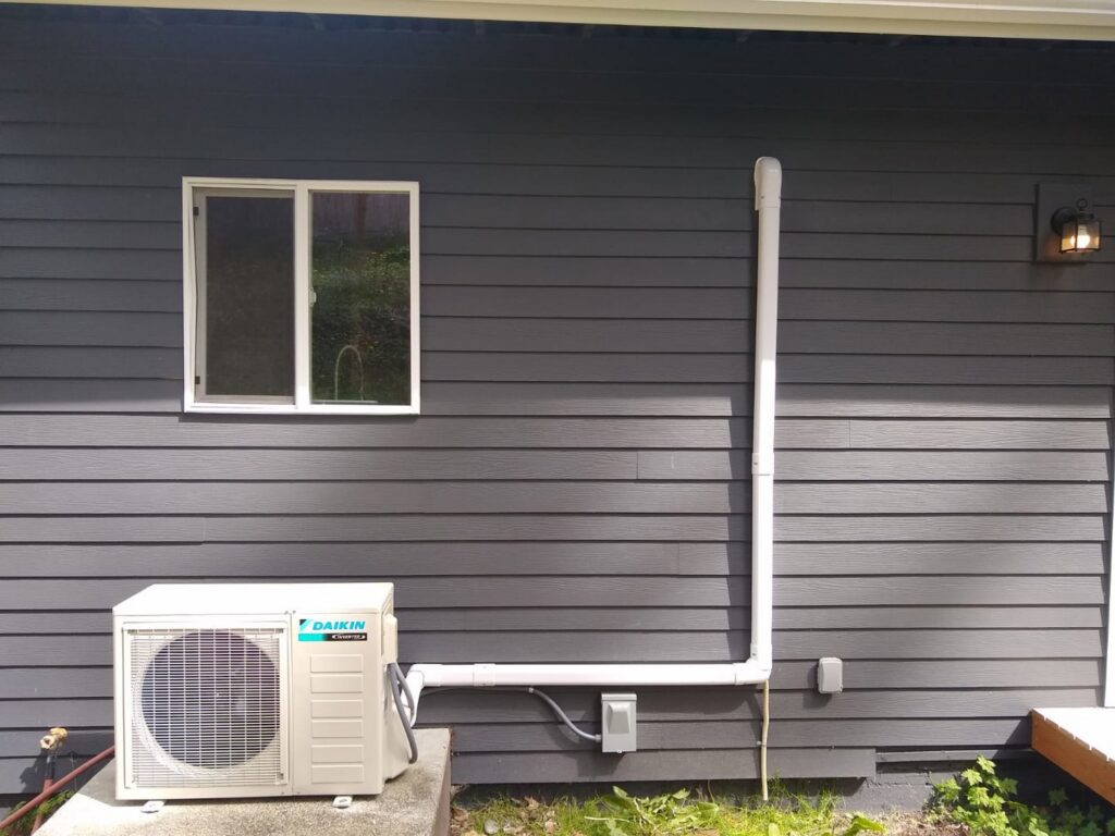 An HVAC technician performing maintenance on a furnace for Dynamic Utility Services, Inc. Heating, A/C & Refrigeration in Shoreline, WA.
