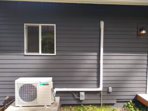 An HVAC technician performing maintenance on a furnace for Dynamic Utility Services, Inc. Heating, A/C & Refrigeration in Shoreline, WA.