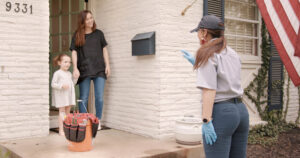 An A.B. May Heating, A/C, Plumbing & Electrical technician greeting a customer for an HVAC service call in Kansas City, MO.