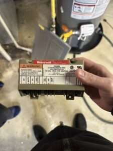 An HVAC technician holding a Honeywell control module during a service call for Airtechservicesohio.com in Columbus, OH