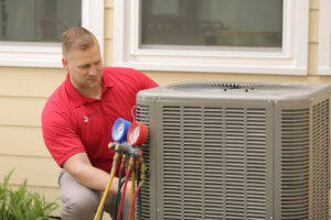 A Service Legends HVAC technician inspecting an outdoor AC unit with gauges in Des Moines, IA.