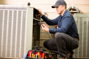 An HVAC technician inspecting an outdoor AC unit with a tablet for Southside Energy in Chesapeake, VA.