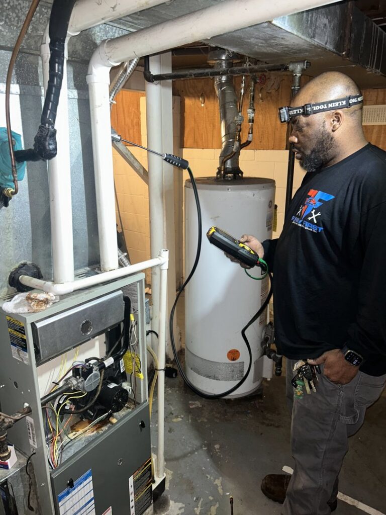 An HVAC technician from Family First Heating and Cooling Repair LLC inspecting a furnace with diagnostic tools in Toledo, OH.