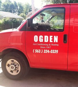 An HVAC technician inspecting an indoor furnace unit for Ogden Air Conditioning & Heating in Davenport, IA.