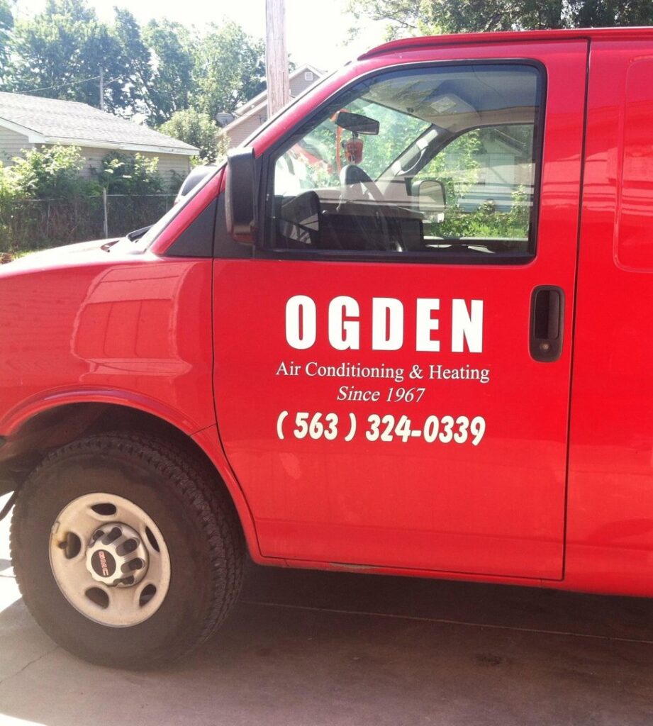 An HVAC technician inspecting an indoor furnace unit for Ogden Air Conditioning & Heating in Davenport, IA.
