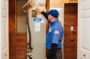 An HVAC technician inspecting a furnace or air handler unit inside a home for Southern Trust Home Services in Roanoke, VA.