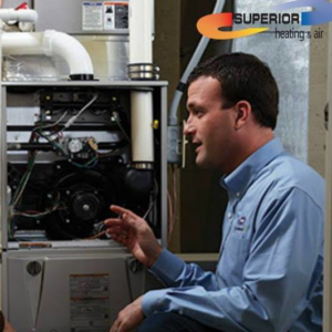 An HVAC technician inspecting a residential furnace unit for Superior Heating & Air in Harvest, AL.