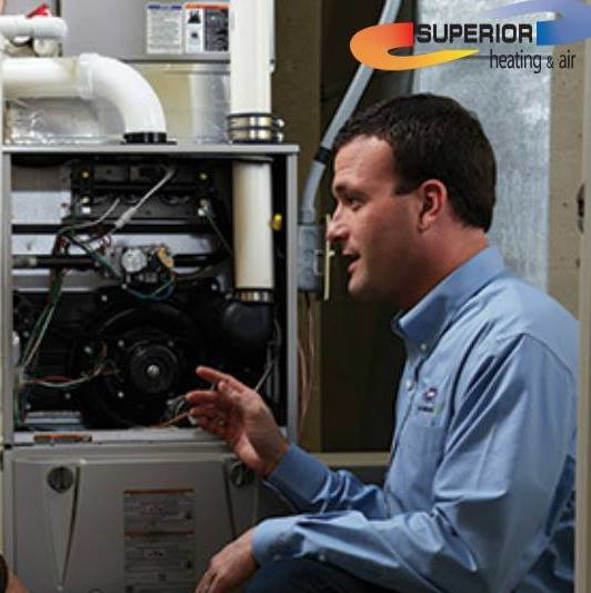 An HVAC technician inspecting a residential furnace unit for Superior Heating & Air in Harvest, AL.