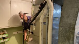 An HVAC technician inspecting a furnace unit for Tom's Heating Service in Waukesha, WI.