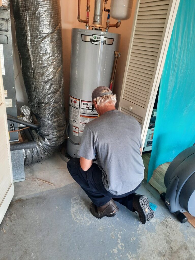 An HVAC technician inspecting an indoor air handler and water heater unit for Pardee Service Experts in Charleston, SC.