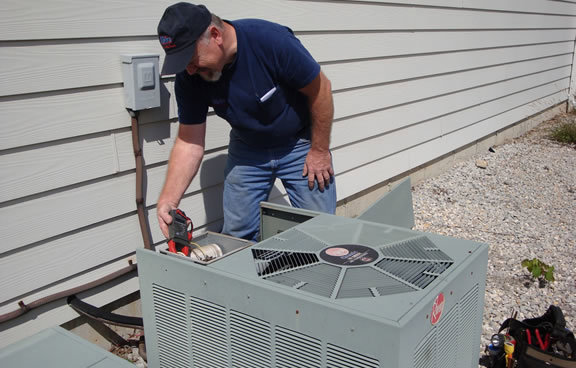 An HVAC technician inspecting an outdoor AC unit for Glendale HVAC in Glendale, AZ