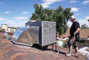 An HVAC technician inspecting a newly installed rooftop HVAC unit by Diamond AC and Heating in Phoenix, AZ.