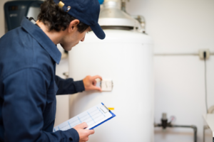 An HVAC technician inspecting a water heater or boiler at a client's location for Eades Heating & Air Conditioning in Springfield, IL.