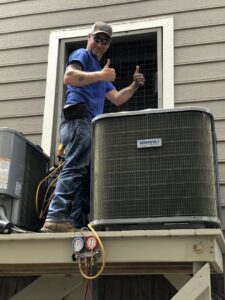 An HVAC technician giving a thumbs up next to a newly installed outdoor AC unit in Sumter, SC by Advance Heating & Air, Inc.
