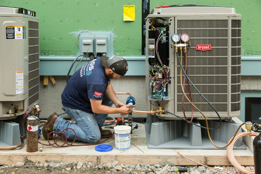An HVAC technician installing copper lines on an outdoor air conditioning unit for Boykin Air Conditioning Services in Sumter, SC.