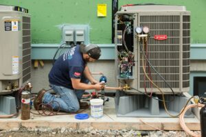 An HVAC technician installing copper lines on an outdoor air conditioning unit for Boykin Air Conditioning Services in Sumter, SC.