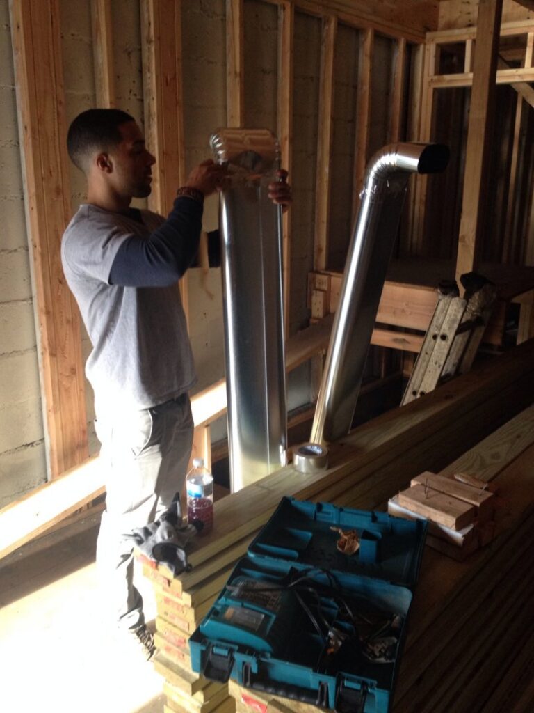 An HVAC technician installing new ductwork in a residential or commercial building by Batista Heating & Cooling, LLC. in Charlotte, NC.