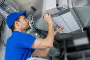 An HVAC technician installing or maintaining a ductwork system for HVAC Erie in Erie, PA.