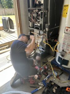 A Best Heat & Air technician installing or repairing an indoor furnace unit in Tacoma, WA.