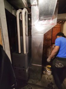 An HVAC technician installing a furnace and ductwork for Zongora Comfort Solutions LLC in Allentown, PA.