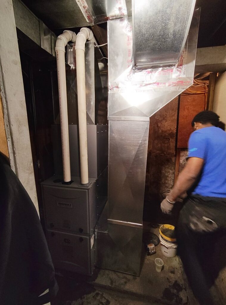 An HVAC technician installing a furnace and ductwork for Zongora Comfort Solutions LLC in Allentown, PA.