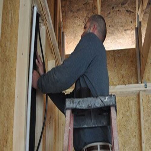 An HVAC technician installing lines during new construction for Foust Heating & Air Conditioning in Fayetteville, NC.