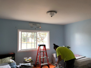 An HVAC technician from Air Perfection, LLC installing a mini-split indoor unit in a home in Waipahu, HI.