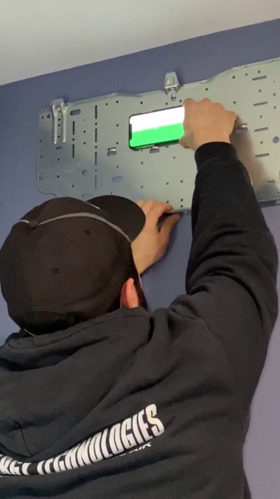 An HVAC technician installing a mounting bracket for a mini-split unit by Energy Technologies in Seattle, WA.