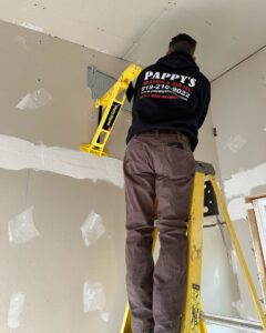 An HVAC technician from Pappy's Heating & Air INC installing a mini-split indoor unit bracket in Clayton, NC.