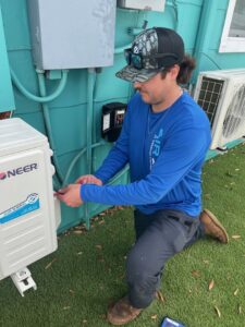 An Air Zero HVAC technician installing or servicing a mini-split outdoor unit in Largo, FL
